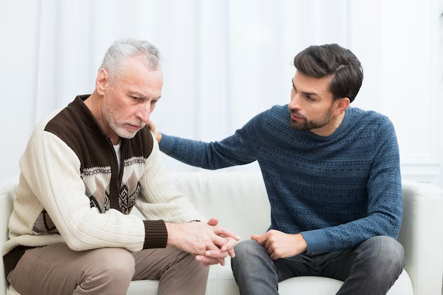 Young guy with his hand on the shoulder of an elderly sad man