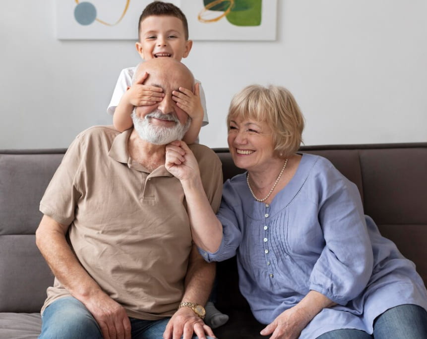 A joyful family moment with a child covering his grandfather's eyes
